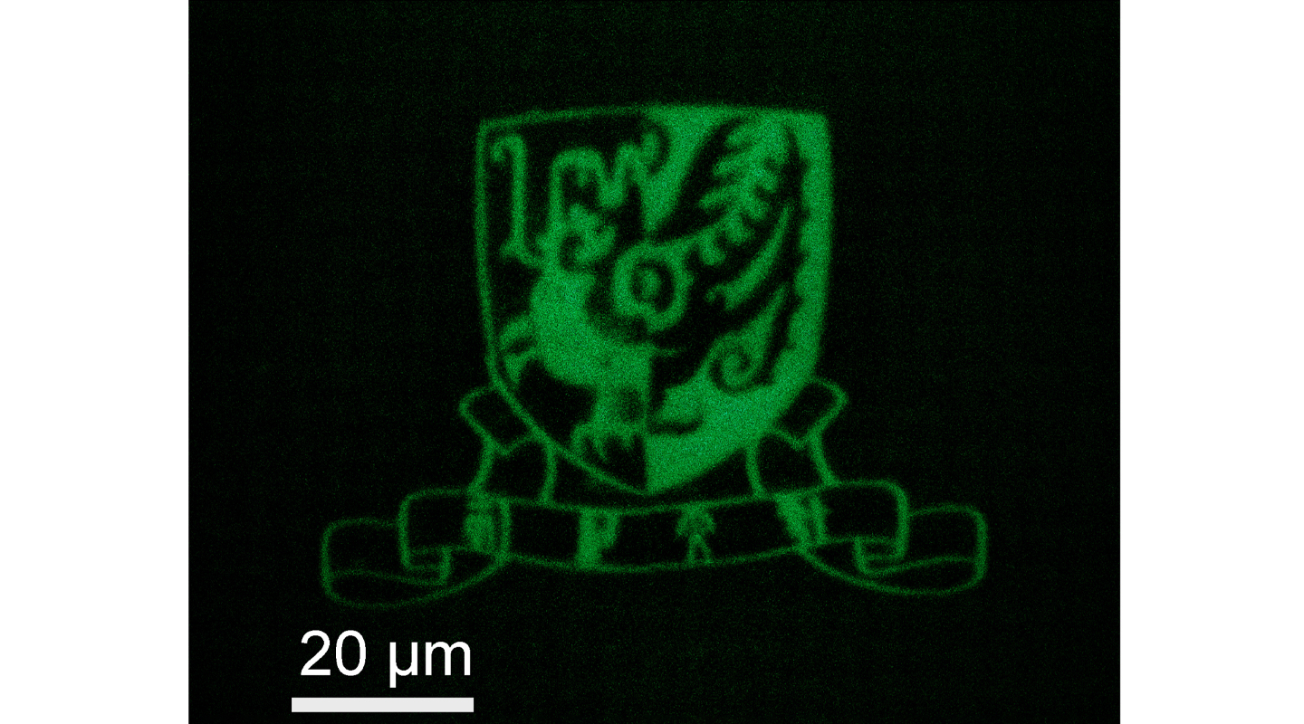 以石墨烯量子点打印而成的中大校徽，由聚焦显微镜拍摄。图中白线长度代表二十微米，约为一根头发丝直径三分一