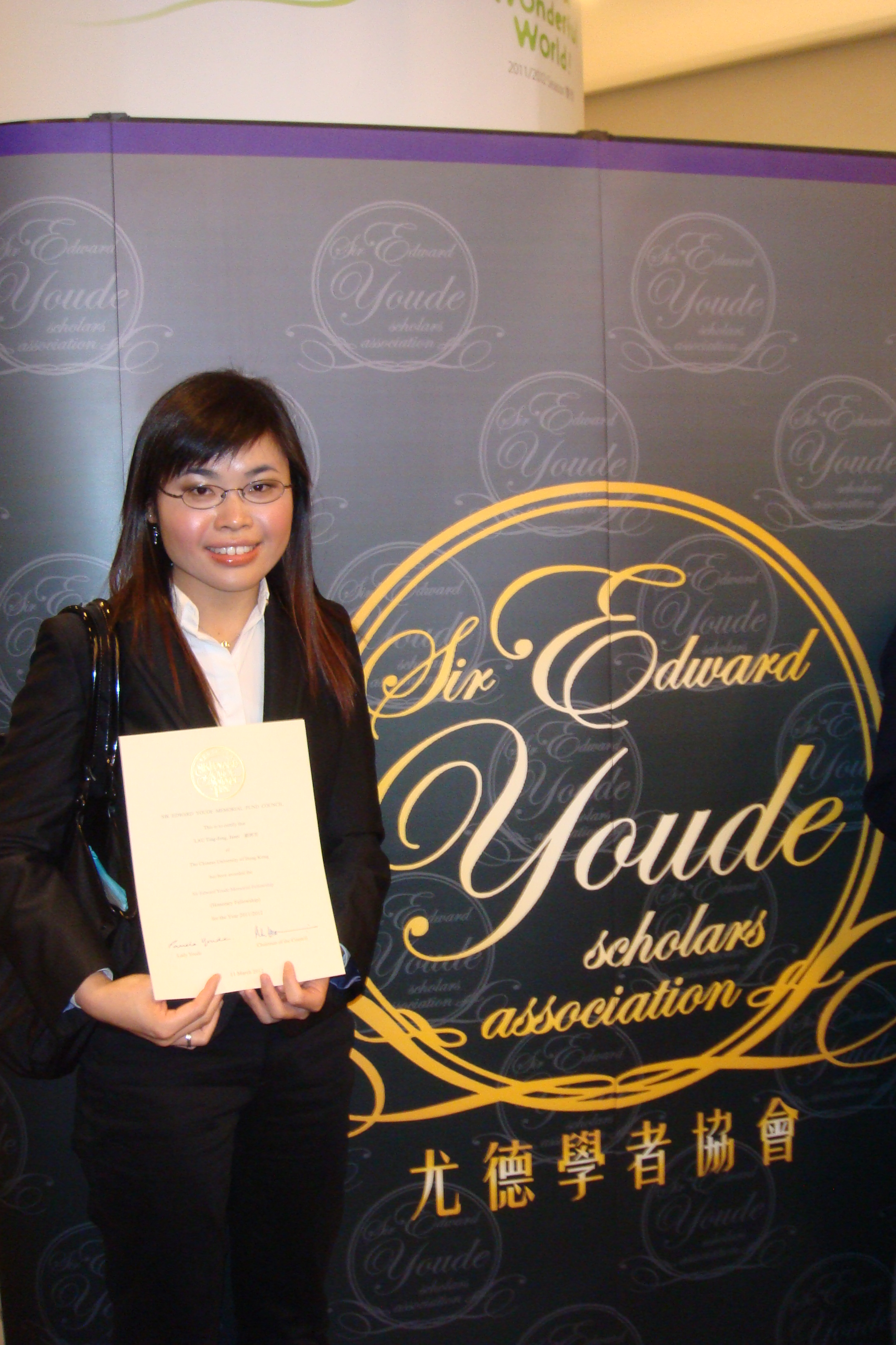 another photo of Ms. Janet Lau Ting Fong and her award certificate