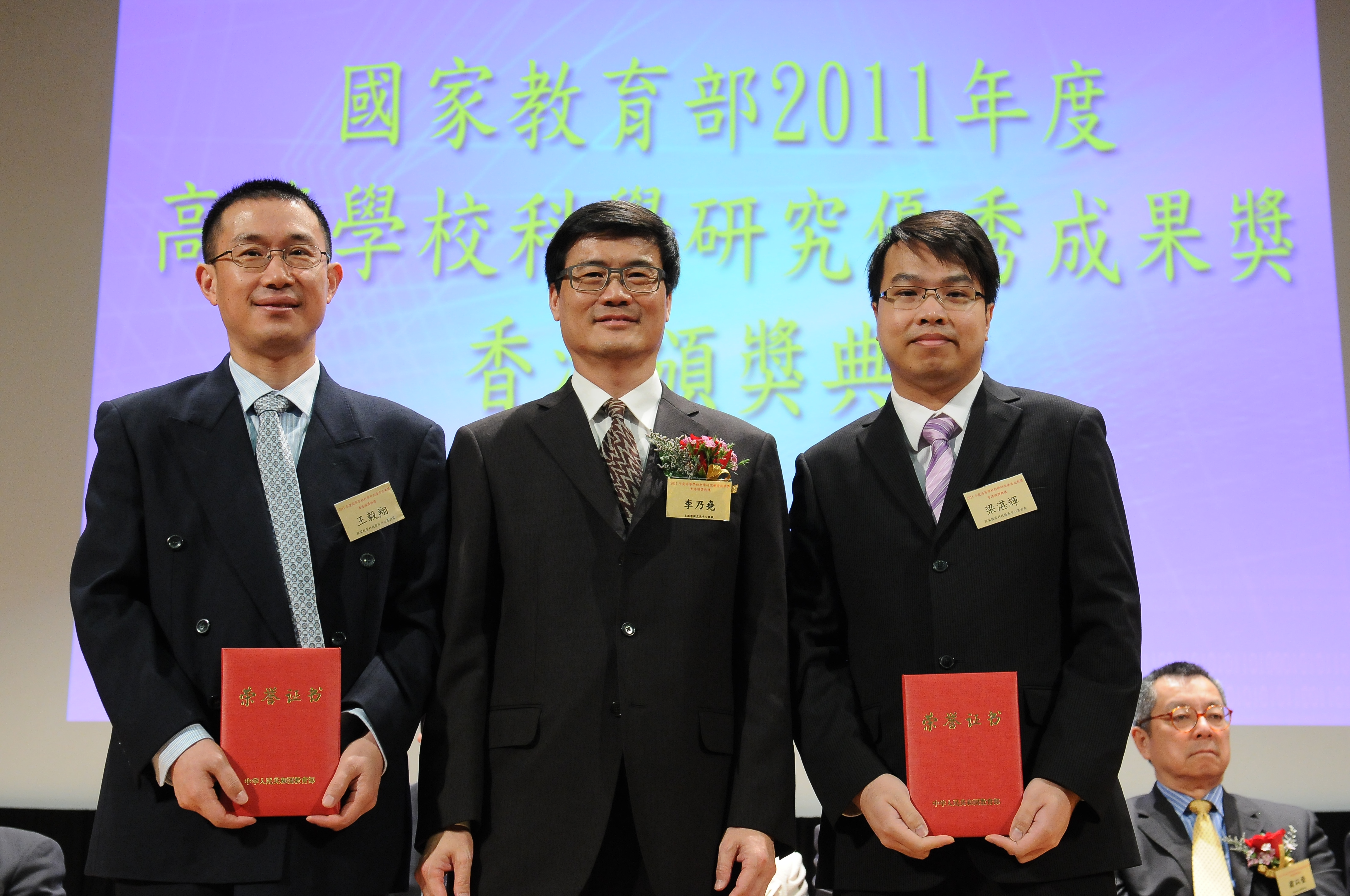 Photo of Prof. Leung Cham-fai Ken receiving the award certificates from Mr. Li Naiyiu, President of Beijing-Hong Kong Academic Exchange Center.