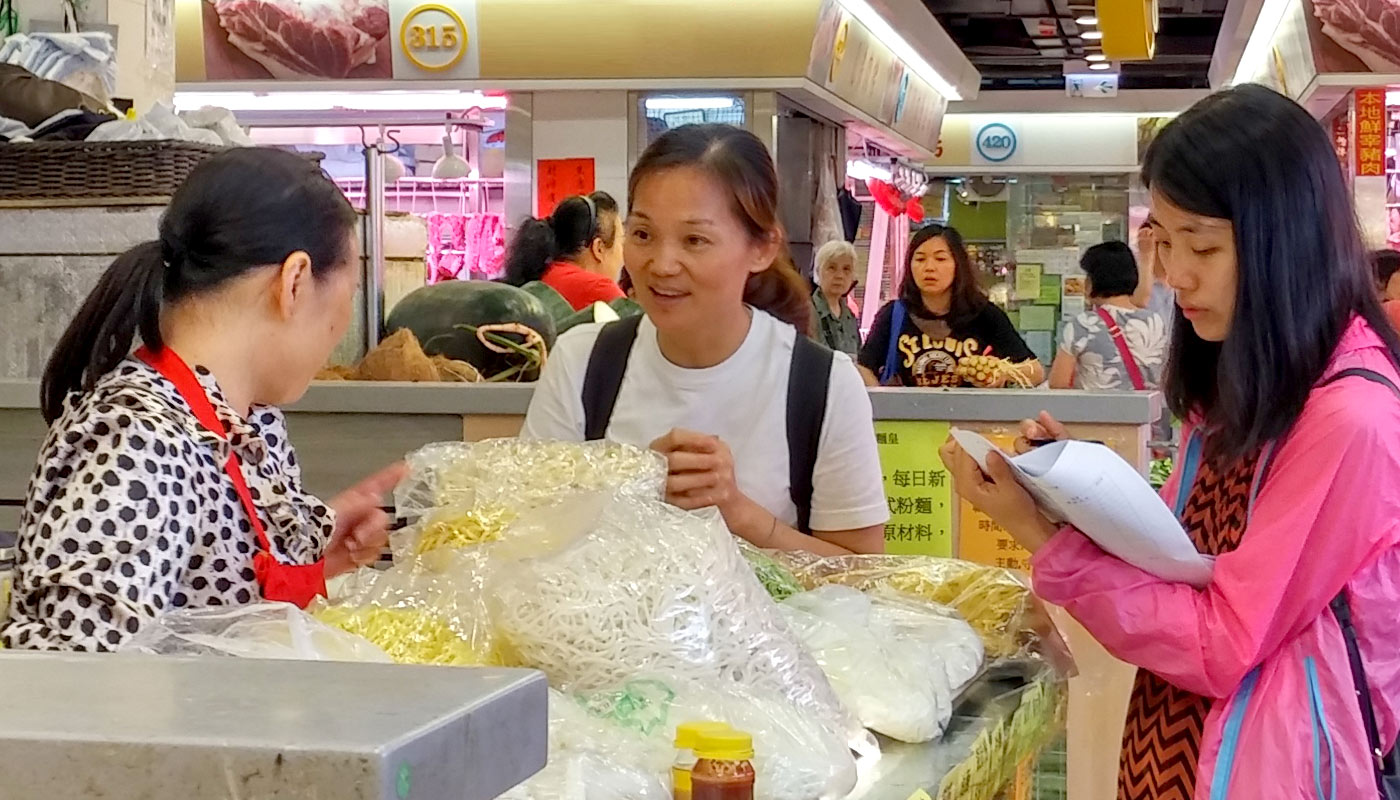 Students team up with a neighbourhood resident to interview tenants at Lok Fu Market